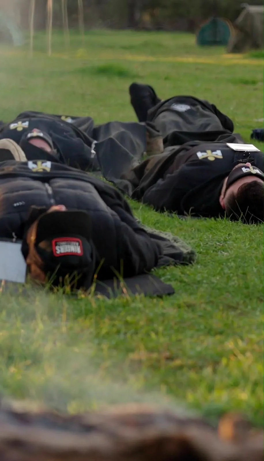 Men lying side by side on the grass during the breathwork session