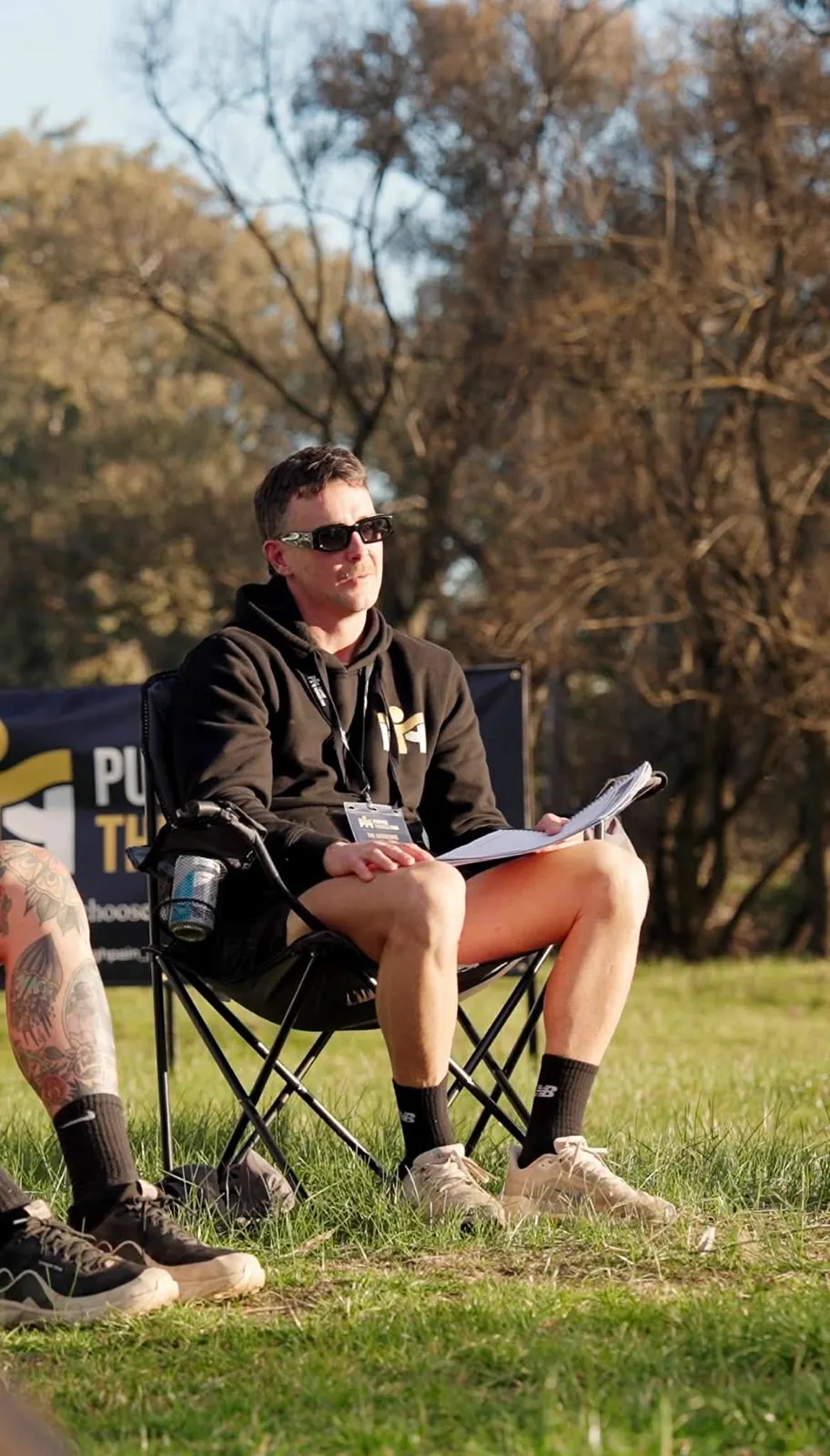 A man sitting in a camp chair with the retreat workbook open on his lap